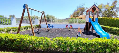 a playground with a slide and a swing at Apartamento Jardines de Deveses by DENIA COSTA in Denia