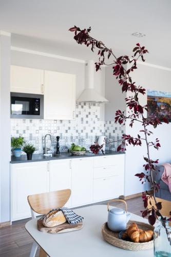 a kitchen with white cabinets and a table with bread at Przystań Łagówek - domki letniskowe in Łagów
