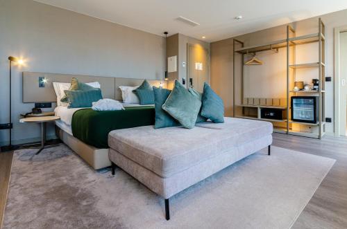 a bedroom with a large bed with blue pillows at OMID Saldanha Hotel in Lisbon
