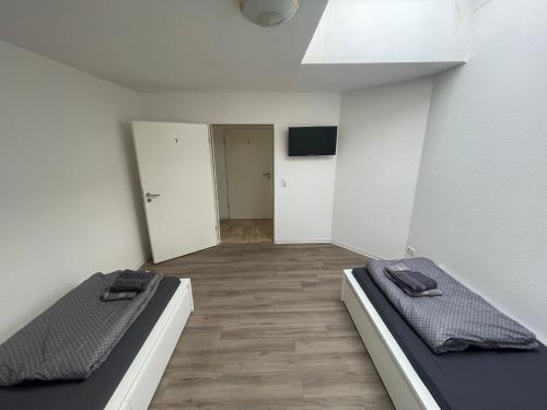 two beds in an empty room with a hallway at Zimmervermietung Am Airport in Bremen