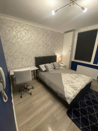 a bedroom with a bed and a desk and a chair at 1 bedroom Luxury Apartments by London City in London