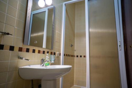 a bathroom with a sink and a shower with a mirror at Lovely Apartment in Tangier