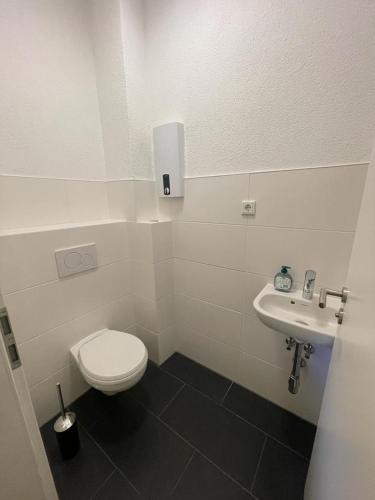 bagno bianco con servizi igienici e lavandino di Zimmervermietung Am Airport a Brema