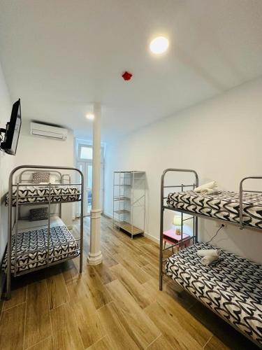 a room with three bunk beds and a wooden floor at HOSTEL COSTA-LUZ Béjar in Huelva