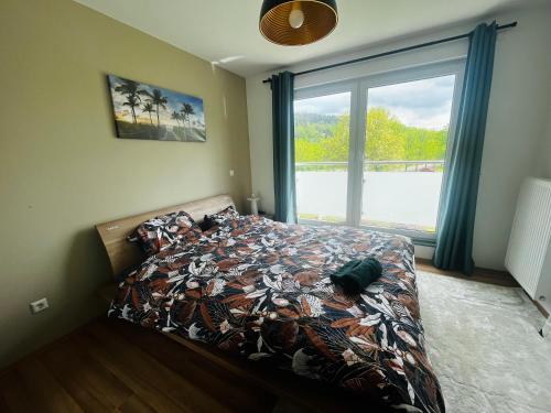 a bedroom with a bed and a large window at Luxembourg City - 70m2 - Easy parking - Bus - 2 TVs - between City and Forest in Luxembourg