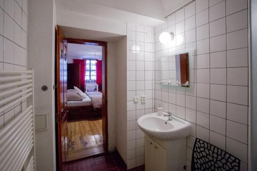 a white bathroom with a sink and a mirror at Apartmán Mariánská 5 in Olomouc