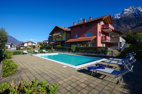 - une piscine en face d'une maison dans l'établissement Residence Girasole Casa Gialla, à Colico