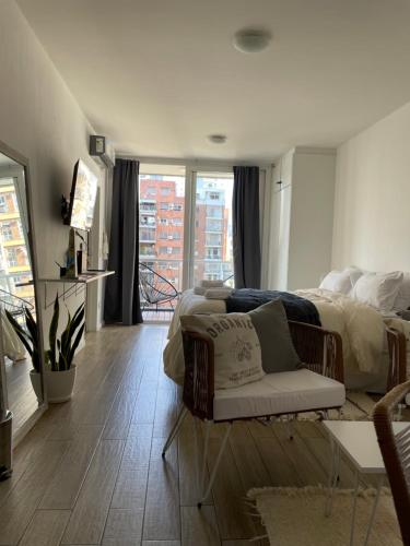 a bedroom with a bed and a chair and a window at Dumont Urban Studio in Buenos Aires