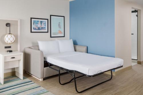 a bed in a room with a couch and a table at Hilton Garden Inn Ocean City Oceanfront in Ocean City
