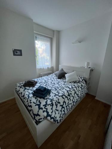 una camera da letto con un letto con un piumone bianco e nero di Cherry's House Milano M1 rossa Bande Nere - San Siro a Milano
