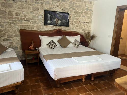 1 dormitorio con 1 cama grande y pared de piedra en Hotel Omer The Ottoman House, en Berat