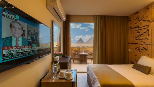 a hotel room with a bed and a flat screen tv at Celia Pyramids View inn in Cairo