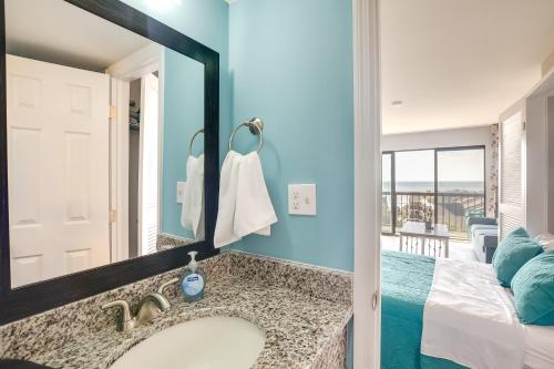 uma casa de banho com um lavatório, um espelho e uma cama em Myrtle Beach Condo with Ocean View and Pool Access! em Myrtle Beach