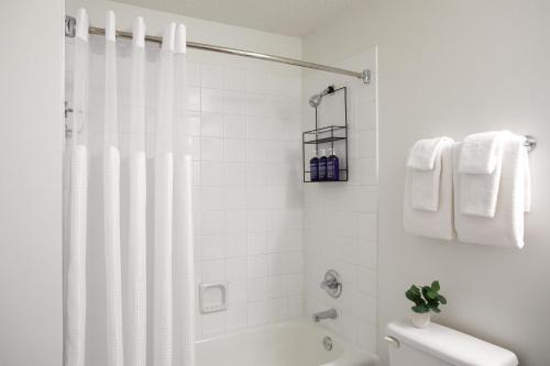 a white bathroom with a shower and a toilet at Kasa Magnificent Mile Chicago in Chicago