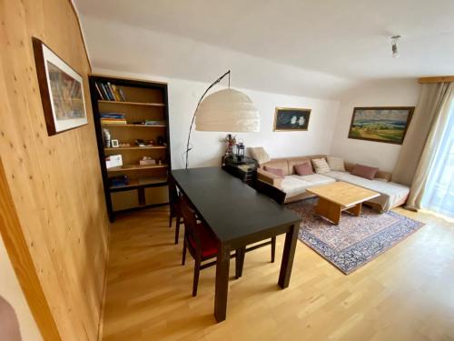 a living room with a table and a couch at Dachsteinblick apartment in Ramsau am Dachstein