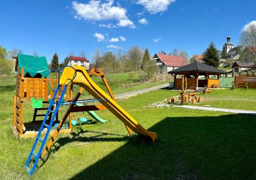 un parque infantil con tobogán y estructura de juegos en Apartamenty na Wyrszczku, en Istebna