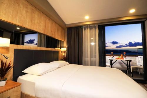 1 dormitorio con 1 cama grande y vistas al océano en Ramada By Wyndham Vakfıkebir en Trebisonda