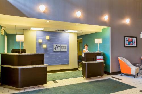 a woman standing at a desk in a lobby at Holiday Inn Express & Suites Burlington - Mount Holly by IHG in Westampton Township