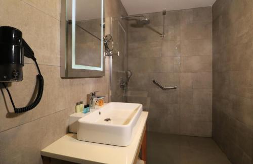 a bathroom with a white sink and a shower at Ramada By Wyndham Vakfıkebir in Trabzon