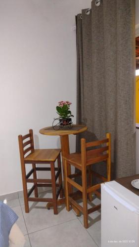 a table and two chairs and a table with a plant on it at Pousada Filhos da Canastra in Vargem Bonita