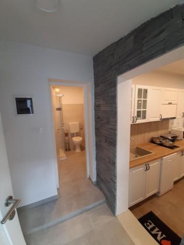a kitchen with a stone wall in a room at PLOMIN SKY&BAY in Plomin
