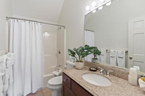 a bathroom with a sink and a toilet and a mirror at Pink Blossoms Resort in Ogunquit