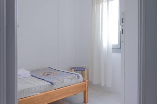 a small bed in a room with a window at Martha's filoxenia in Drios
