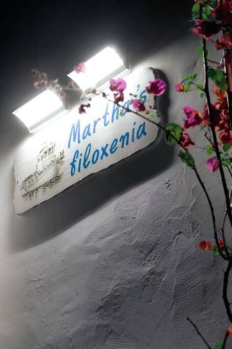 a sign on a wall with flowers on it at Martha's filoxenia in Drios