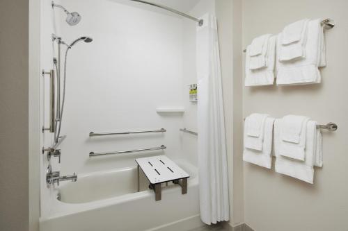 a bathroom with a shower and a bath tub with towels at Holiday Inn Express & Suites Gulf Breeze - Pensacola Area, an IHG Hotel in Gulf Breeze