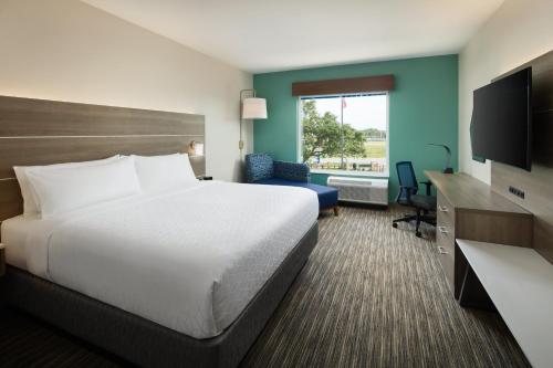 a hotel room with a bed and a television at Holiday Inn Express & Suites Gulf Breeze - Pensacola Area, an IHG Hotel in Gulf Breeze