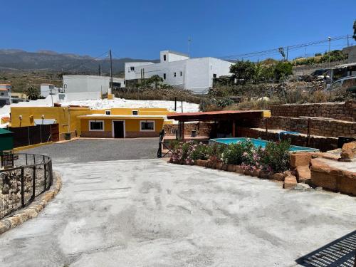 um parque de estacionamento em frente a um edifício amarelo em Casa Cueva Los Mansos em Santa Cruz de Tenerife