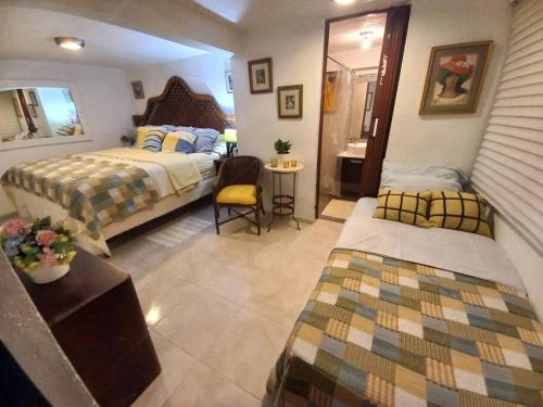 a large bedroom with two beds and a mirror at Estancia Sonrisas de Ángeles in Constanza