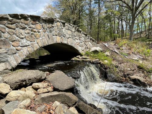 a stone bridge over a stream with a waterfall at One bedroom with modern kitchen, balcony with water view in Greenwich