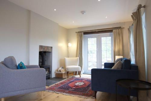 sala de estar con 2 sofás azules y chimenea en Pentreath, Crackington Haven, en Crackington Haven