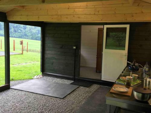 a small cabin with a door and a table with food at Foxgloves and Fairytales Hut with Hot Tub in Llanwrda