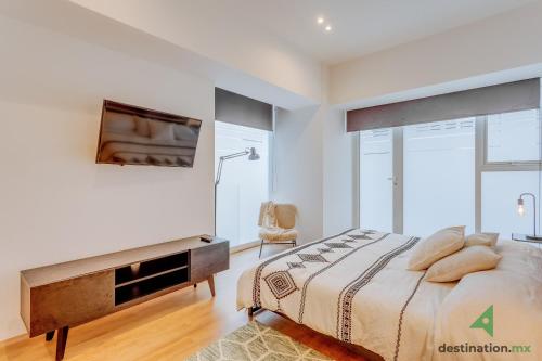 a bedroom with a bed and a tv on a wall at Lovely & Spacious Apartment with Pool & Gym in La Condesa - Icon in Mexico City