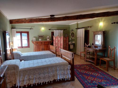 een slaapkamer met 2 bedden, een tafel en een bureau bij VILLINO AMELIATTE in Cison di Valmarino