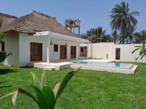 a house with a swimming pool in the yard at la maison de la fontaine in Cap Skirring