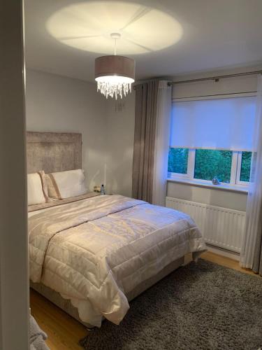 a bedroom with a bed with a chandelier and a window at Inse House Laytown in Laytown