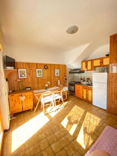 a kitchen with a table and a white refrigerator at Un posto al sole in Fregene