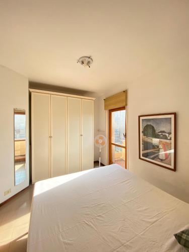 a bedroom with a large white bed and a window at Un posto al sole in Fregene