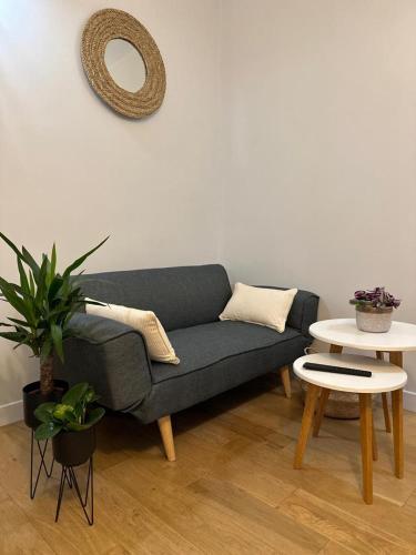 - un salon avec un canapé, deux tables et un miroir dans l'établissement Studio -Champs Élysées, à Paris