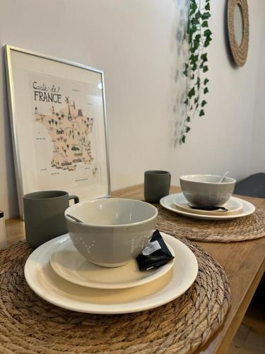 une table en bois avec deux bols et des assiettes dans l'établissement Studio -Champs Élysées, à Paris