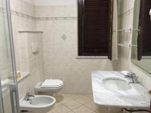 een witte badkamer met een wastafel en een toilet bij Il Girasole - Ginestra in Venturina Terme