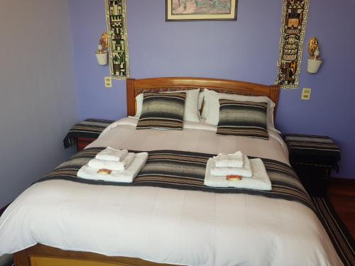 a bedroom with a bed with towels on it at Hostal Phaxsi in Comunidad Yumani