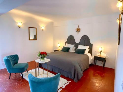 une chambre avec un lit et une chaise bleue dans l'établissement La Grande Verrière - Luberon en Provence, à Goult