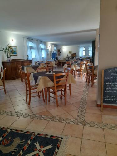 uma sala de jantar com mesas e cadeiras num restaurante em Agriturismo Palas De Serra Country Resort em Onifai