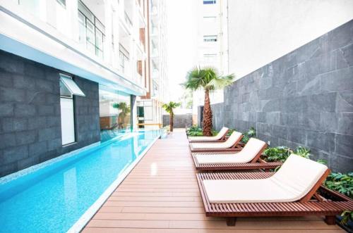 a row of chaise lounge chairs next to a swimming pool at Lovely & Spacious Apartment with Pool & Gym in La Condesa - Icon in Mexico City