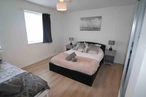 Un dormitorio con una cama con almohadas. en Spacious three bedroom house with off road parking, en Birmingham