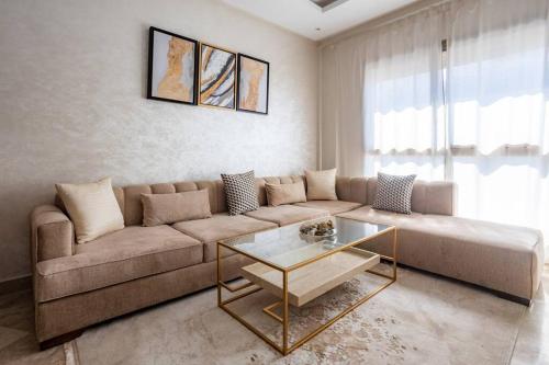 - un salon avec un canapé et une table en verre dans l'établissement Modern Charm at Le Joyau du Parc, à Mohammedia